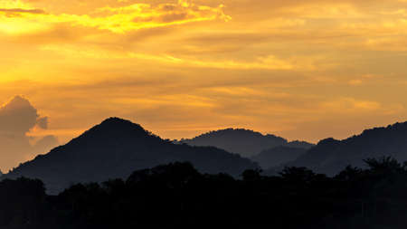 silhouette mountain with attractive background, sunset with vivid purple sky and lakeの写真素材