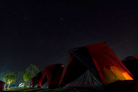 The orange tent under night sky and stars at Phu Kra Dueng National Park of Thailandの写真素材