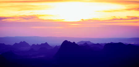 A panoramic landscape of mountain ridges with twilight sky and clouds at Phu Kra Dung National park of Thailandの写真素材