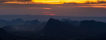 A panoramic landscape of mountain ridges with sunset sky and clouds at Phu Kra Dung National park of Thailandの写真素材