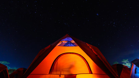 The orange tent under night sky and stars at Phu Kra Dung National Park of Thailandの写真素材