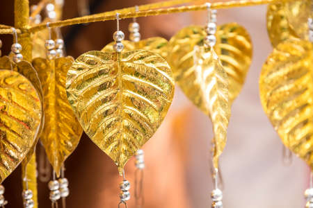 Golden bo leaf are hanged on rope in the templeの写真素材
