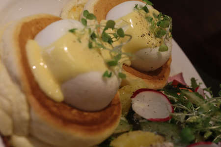 eggs benedict with pancakes and salad