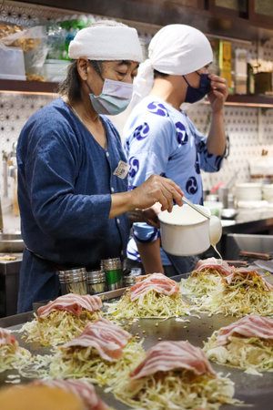 At a Hiroshima Okonomiyak (Konomiyaki) restaurant called "Chitetsu" on Fushun Street in Zhongshan District, Taipei, a chef is cooking delicious food on a hotplate.のeditorial素材