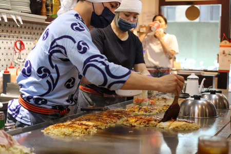 At a Hiroshima Okonomiyak (Konomiyaki) restaurant called "Chitetsu" on Fushun Street in Zhongshan District, Taipei, a chef is cooking delicious food on a hotplate.のeditorial素材