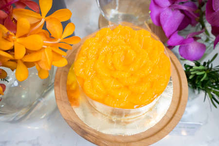 orange cake with fresh orange surrounded by tropical flowers decoration