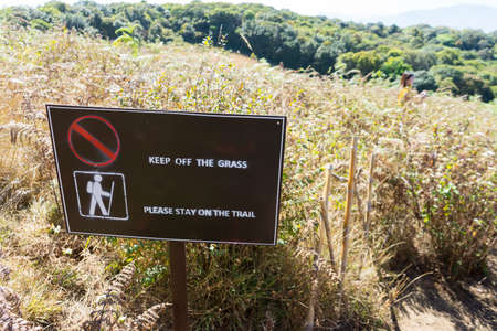 Keep off the grass please stay on the trail signの写真素材