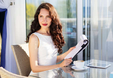 Girl spending time in a cafe using digital tabletの写真素材