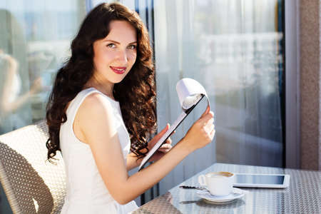 Girl spending time in a cafe using digital tablet