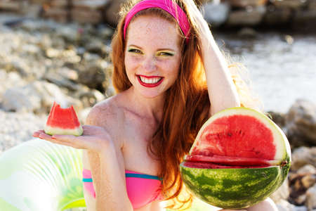 Smiling girl with freckles holding watermelonの写真素材