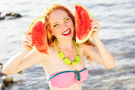 Smiling girl with freckles holding watermelonの写真素材