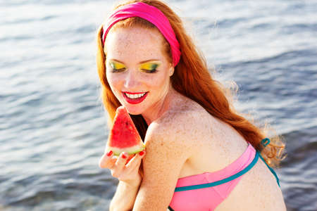 Smiling girl with freckles holding watermelonの写真素材