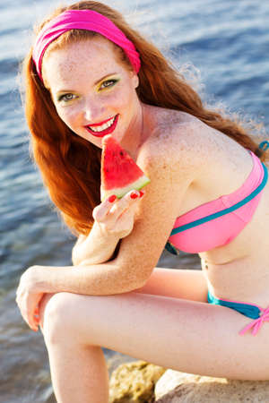 Smiling girl with freckles holding watermelonの写真素材