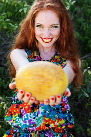 Smiling girl with freckles holding corn cobの写真素材