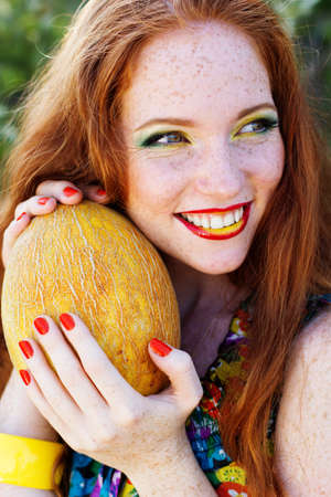 Smiling girl with freckles holding corn cobの写真素材
