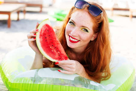 Smiling girl with freckles holding watermelonの写真素材