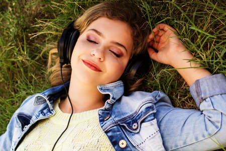 Young happy teenager is wearing headphones