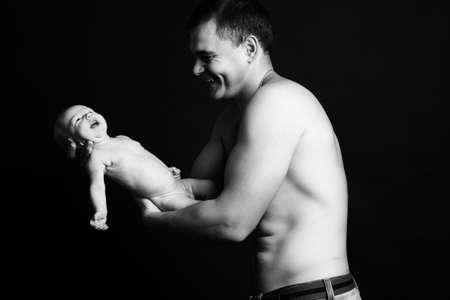 Infant baby boy on his father\'s armsの写真素材