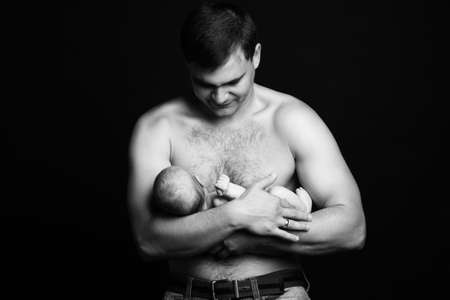 Infant baby boy on his father\'s armsの写真素材