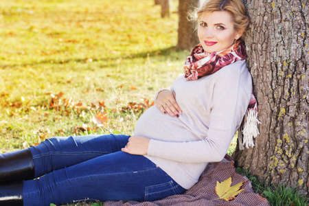 Pregnant girl in autumn parkの写真素材