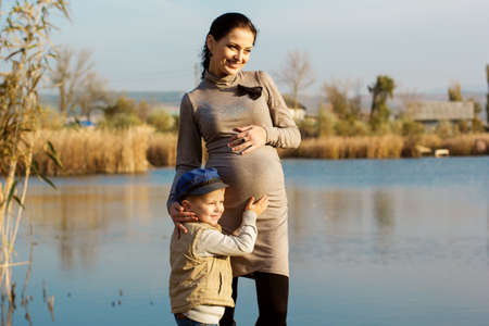Little boy with her mother on the autumn lakeの写真素材