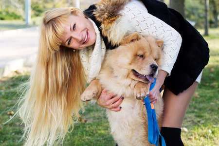 Attractive girl with her dog wearing warm clothesの写真素材