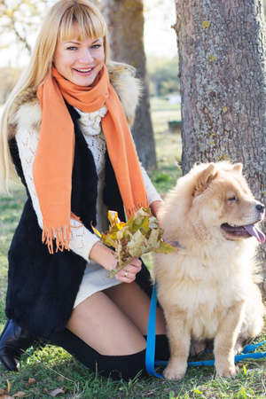 Attractive girl with her dog wearing warm clothesの写真素材