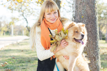 Attractive girl with her dog wearing warm clothesの写真素材