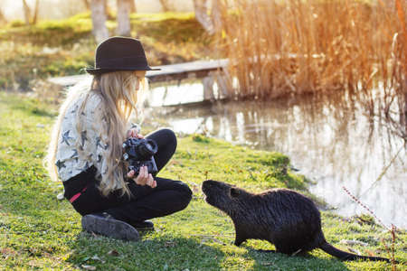 Cute little girl is resting near lake with cameraの写真素材