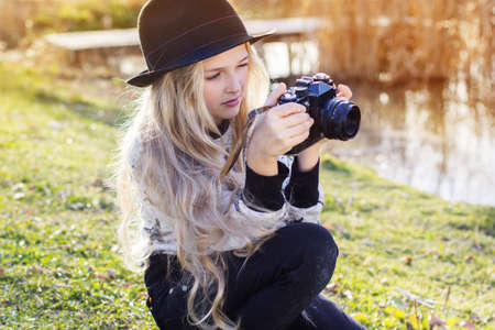 Cute little girl is resting near lake with cameraの写真素材