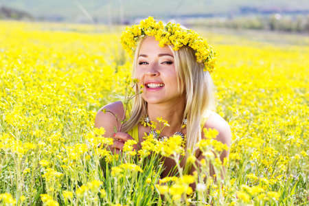 Young beautiful girl in the field of yellow flowersの写真素材