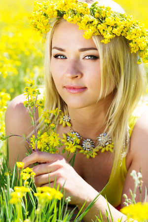 Young beautiful girl in the field of yellow flowersの写真素材