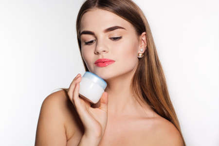 Portrait of attractive caucasian girl with perfect skin isolated on white in studio is holding face...