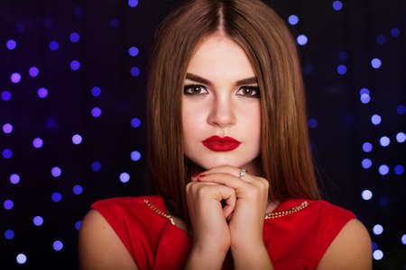 Pretty girl is wearing red fashion dress with smoky eyes makeupの写真素材