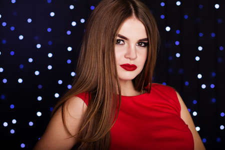 Pretty girl is wearing red fashion dress with smoky eyes makeup