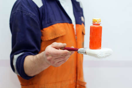 Man with paint brush and orange color tube, closeup pictureの写真素材