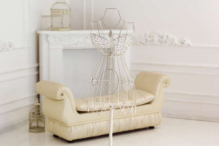 White vintage metal hanger with wire dress form in white home interiorの写真素材
