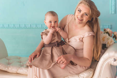 Beautiful young fashion mother is playing with little baby girlの写真素材