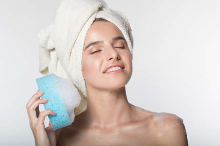Girl with towel on her head is holding wisp with foamの写真素材