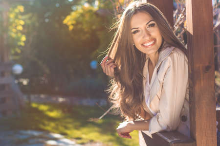 Young fashion girl with perfect smile is having fun in autumn park
