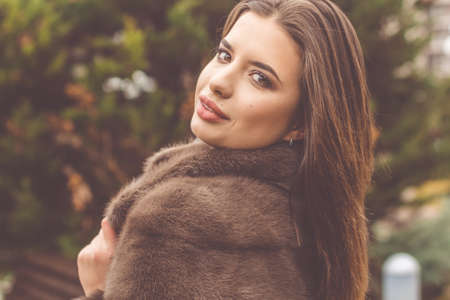 Pretty teen girl is wearing fur coatの写真素材