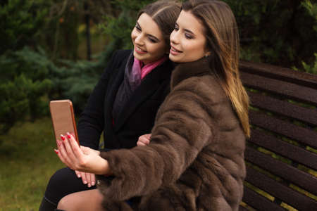 Two pretty girls are taking selfie with smartphoneの写真素材