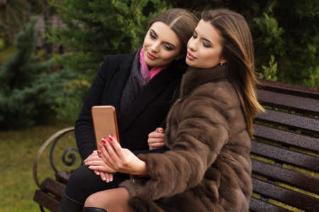 Two teen girls are taking selfie with smartphoneの写真素材