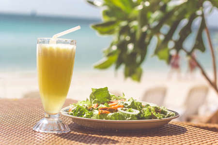 Seafood salad, orange fresh juice on the table near seaの写真素材