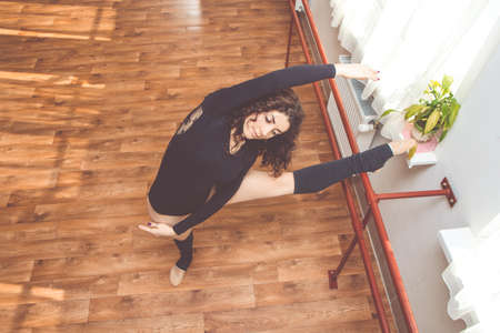Woman is stretching her legs near ballet benchの写真素材
