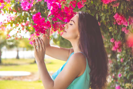 Portrait of pretty woman posing near pink flowersの写真素材