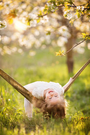 Child girl is having fun in hammock outdoorsの写真素材