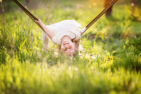 Child girl is having fun in hammock outdoorsの写真素材