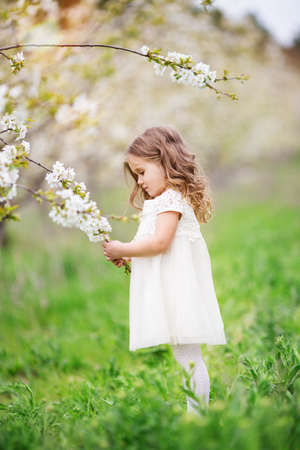 Pretty child girl in blossom gardenの写真素材