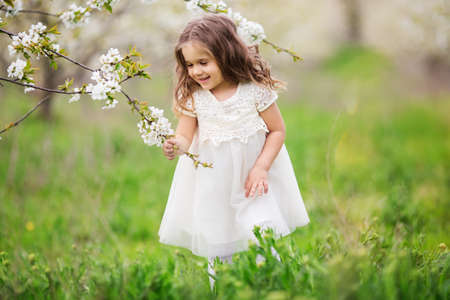 Pretty child girl in blossom gardenの写真素材